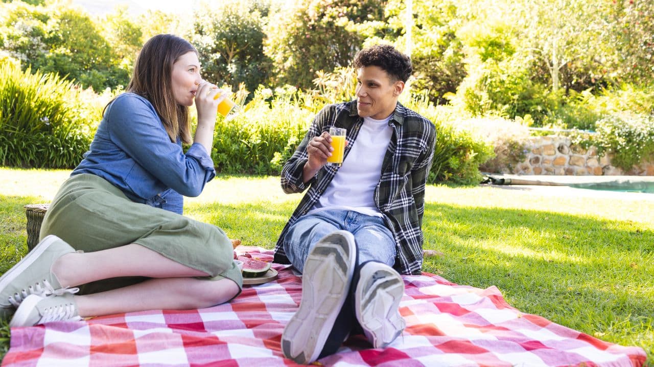 Casal tomando suco em um piquenique