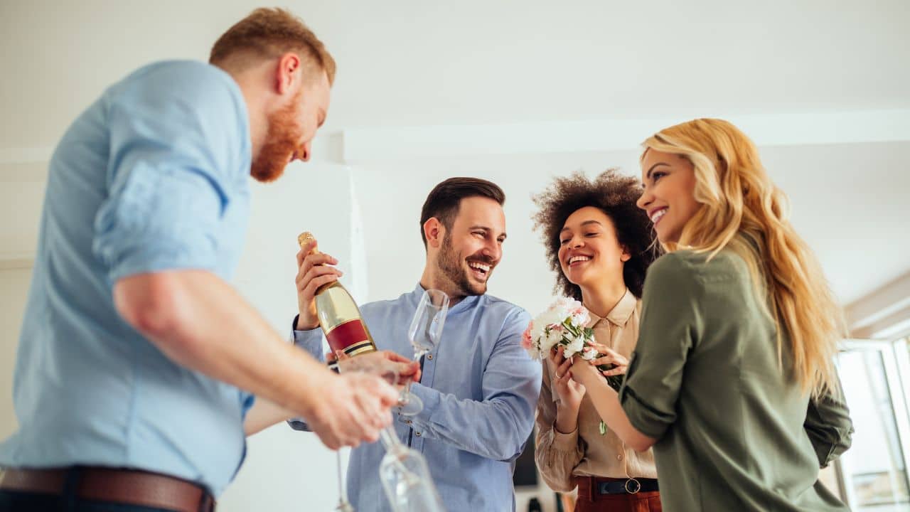 Mulher loira celebra com amiga e dois amigos casa nova com brinde de champanhe